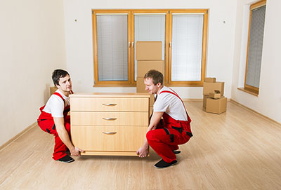 many hand makes light work, image of two men lifting a chest of drawers