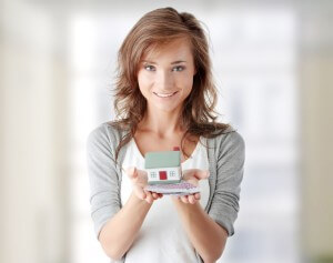 Image of lady holding a model of a house