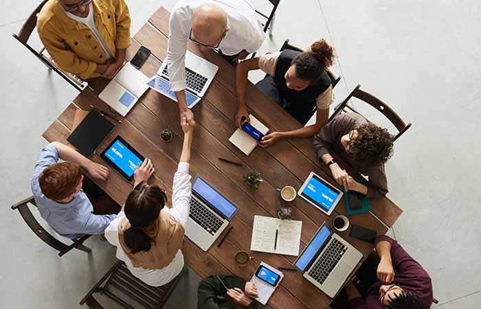 business meeting around a wooden table to represent a suburban office move